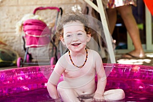 Funny toddler laughing in a pool