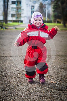 Funny toddler runs in the yard in winter