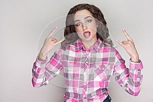 Funny tongue out beautiful girl with pink checkered shirt, curly