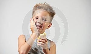 Funny toothless boy with sensitive teeth holding ice cream