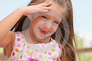Funny toothless little girl outdoors