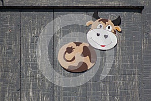 Funny toy cow on flaked grey background