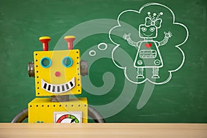 Funny toy robot teacher against chalkboard