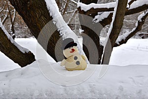 Funny toy snowman standing under a tree