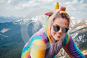 Portrait of female hiker in a unicorn costume in mountains