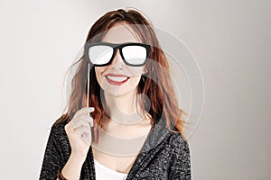 Funny trendy fashion girl with paper glasses playing with emotion