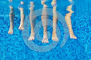 Funny underwater family legs in swimming pool