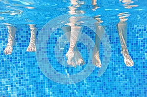 Funny underwater family legs in swimming pool