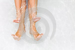 Funny underwater photo of bare feet in swimming pool