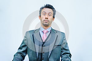 Funny unshaven man in suit with tie on gray background