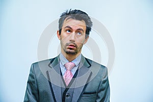 Funny unshaven man in suit with tie on gray background