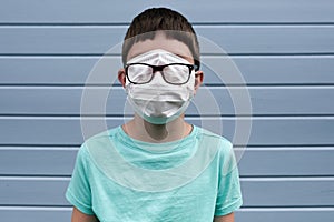 A funny view of a boy wearing white protective surgical medical mask, covering even his eyes to prevent infection during epidemia photo