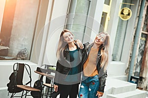 It is funny walk with best friend! Two beautiful women walking outdoor hugging and laughing on autumn street.