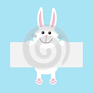 Funny white rabbit hare hanging on paper board template.