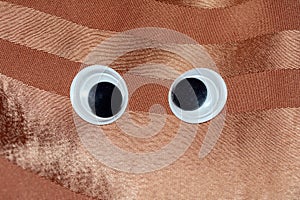 Funny Wiggle Google Eyes on Fabric Background