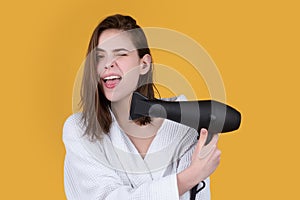 Funny woman blow drying her hair. Young girl with drying hair with hair dry.