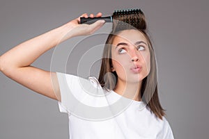 Funny woman brushing hair with comb. Beautiful girl with long hair hairbrush.