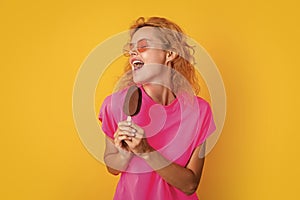 funny woman with icelolly ice cream isolated on yellow. woman with icelolly ice cream photo