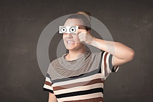Funny woman looking with hand drawn paper eyes
