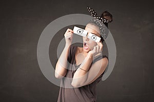 Funny woman looking with hand drawn paper eyes