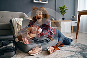 Funny woman packing luggage for vacation trip