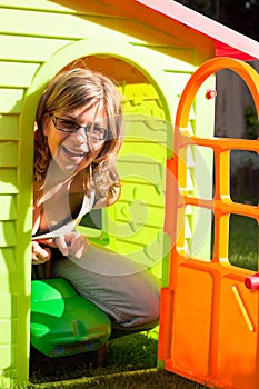 Funny woman playing in playhouse