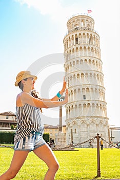 Funny woman supporting leaning tower of pisa