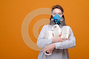 funny woman with with toilet paper in hand in protective equipment in medical mask on yellow background, coronavirus pandemic,