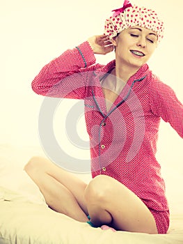 Funny woman wearing pajamas and bathing cap