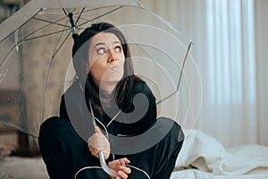Funny Woman Wearing Pajamas Holding an Umbrella in Bed