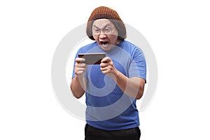 Funny Young Asian Guy Playing Games on Tablet Smart Phone