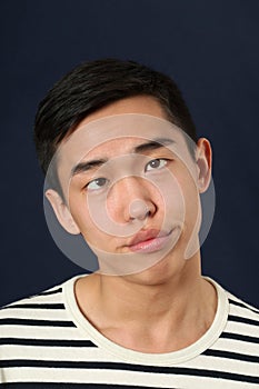 Funny young Asian man making face