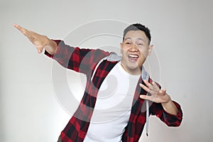 Funny young Asian man smiling and dancing happily, joyful expressing celebrating good news victory winning success