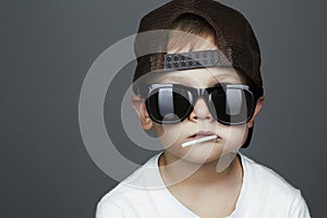 Funny Young Boy Eating A Lollipop.child in sunglasses