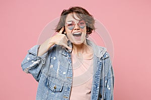 Funny young brunette woman girl in casual denim jacket eyeglasses posing isolated on pastel pink background. People