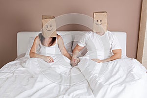 Funny young couple with paper bags over heads