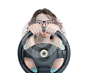 Funny young girl in glasses driver car with a steering wheel, isolated on white background
