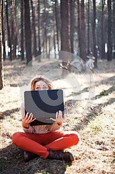 Funny young girl with laptop outdoors