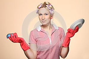 Funny young housewife with gloves holding scrubberr