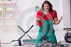 Funny young male electrician working indoors