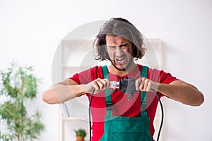 Funny young male electrician working indoors