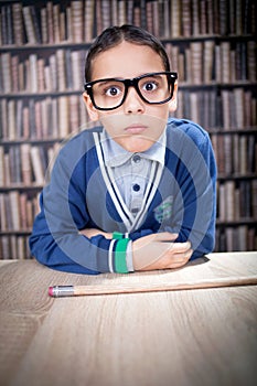 Funny young scientist, hustler with glasses in a library