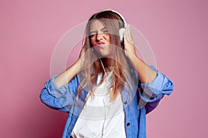Funny young woman dancing and listening to music studio portrait