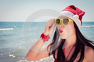 Funny young woman in Santa Claus hat and sunglasses