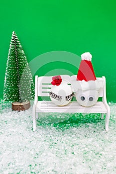 Funy pair made of a balls  on a banch and Christmas tree and snow.Winter Christmas Holiday concept