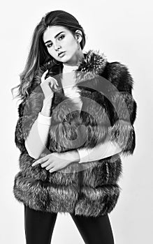 Fur store model posing in soft fluffy warm coat. Pretty fashionista. Fur fashion concept. Woman makeup and hairstyle