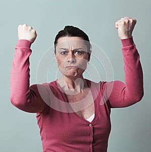 Furious 40s woman flexing her muscles up for female independence