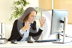 Furious businesswoman using a computer photo