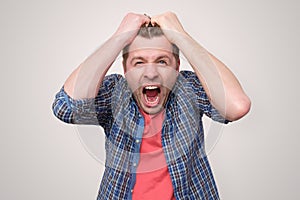 Furious, enraged man with mouth opened in shout