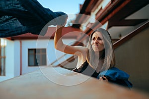 Furious Girlfriend Throwing Boyfriend Clothes Over the Balcony